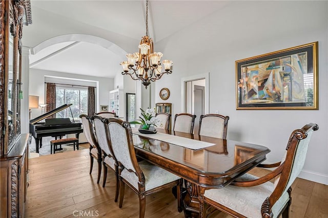 25291 Derbyhill Dr, Laguna Hills, CA 92653 - dining room with arched walkways, hardwood / wood-style floors, vaulted ceiling, and a chandelier