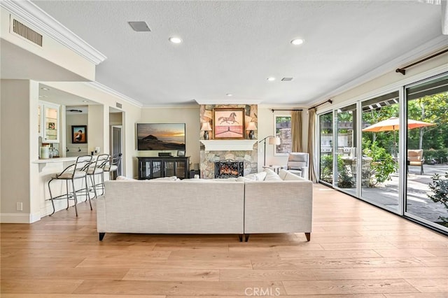 25291 Derbyhill Dr, Laguna Hills, CA 92653 - living area with a stone fireplace, crown molding, light wood finished floors, recessed lighting, and a textured ceiling