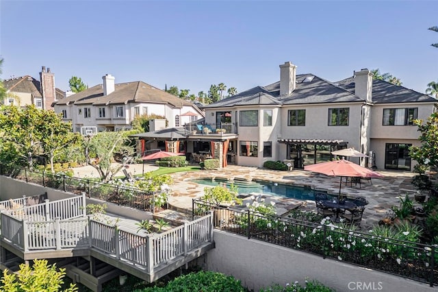 25291 Derbyhill Dr, Laguna Hills, CA 92653 - back of house featuring stucco siding, a wooden deck, an outdoor pool, a patio area, and a hot tub