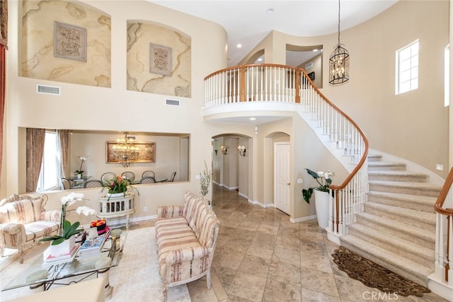 2 Shadow, Irvine, CA 92620 - living room with a chandelier, a high ceiling, arched walkways, stairs, and stone finish floors