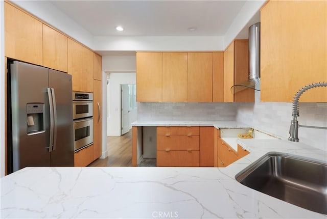 3 Longbourn Aisle, Irvine, CA 92603 - kitchen featuring stainless steel appliances, wall chimney range hood, light stone countertops, decorative backsplash, and recessed lighting