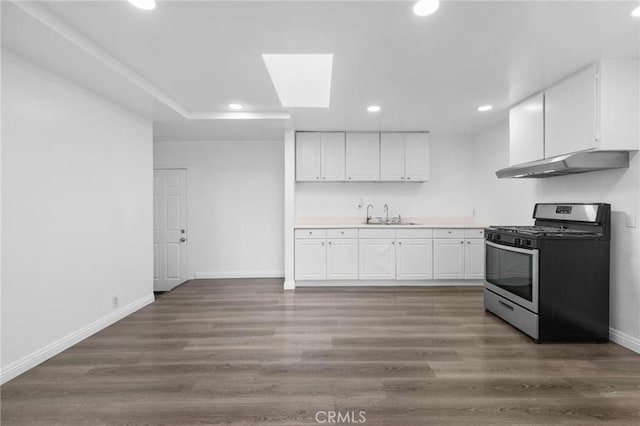 3310 Mangum St, Baldwin Park, CA 91706 - kitchen with gas range, under cabinet range hood, recessed lighting, white cabinetry, and light countertops