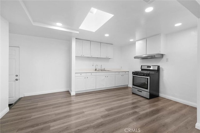 3310 Mangum St, Baldwin Park, CA 91706 - kitchen with gas range, under cabinet range hood, white cabinets, light countertops, and recessed lighting