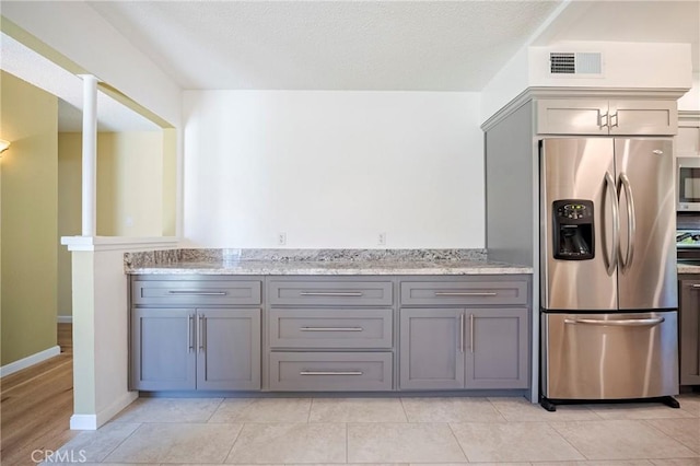 2601 Hoover Ct, Merced, CA 95340 - kitchen with appliances with stainless steel finishes, gray cabinets, and light stone countertops
