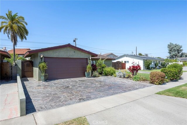 5837 Los Arcos Way, Buena Park, CA 90620 - ranch-style house featuring an attached garage, a gate, driveway, and stucco siding
