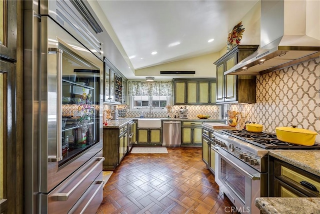 5837 Los Arcos Way, Buena Park, CA 90620 - kitchen featuring high quality appliances, wall chimney range hood, green cabinets, vaulted ceiling, and decorative backsplash