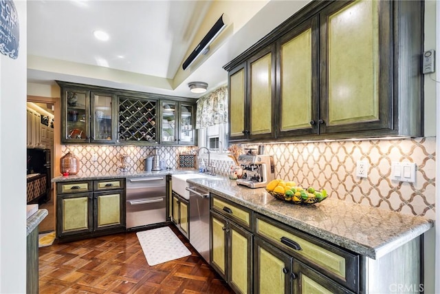 5837 Los Arcos Way, Buena Park, CA 90620 - kitchen with backsplash, stainless steel dishwasher, light stone counters, green cabinetry, and glass insert cabinets