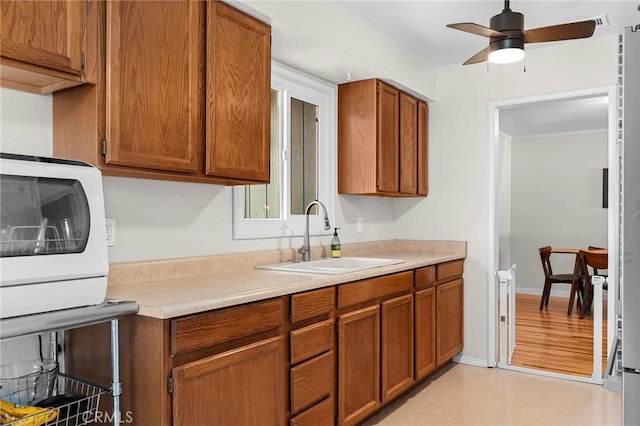 886 Lynn Ln, Chico, CA 95926 - kitchen featuring light countertops, brown cabinetry, and a ceiling fan