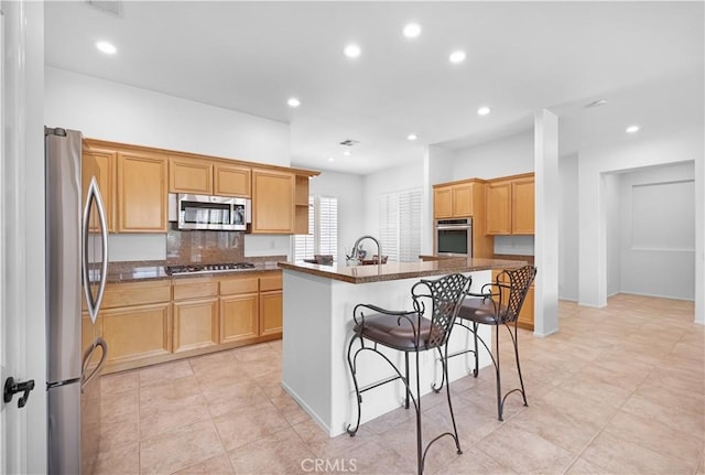 44397 Mesquite Dr, Indian Wells, CA 92210 - kitchen with appliances with stainless steel finishes, a kitchen breakfast bar, recessed lighting, a center island with sink, and dark stone counters
