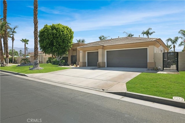 44397 Mesquite Dr, Indian Wells, CA 92210 - view of front of home featuring concrete driveway, a front yard, stucco siding, a gate, and an attached garage