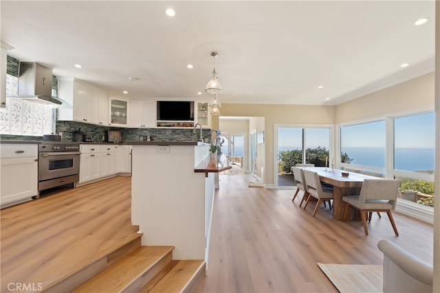 3666 Greve Dr, Rancho Palos Verdes, CA 90275 - kitchen featuring wall chimney range hood, high end range, tasteful backsplash, white cabinetry, and dark countertops