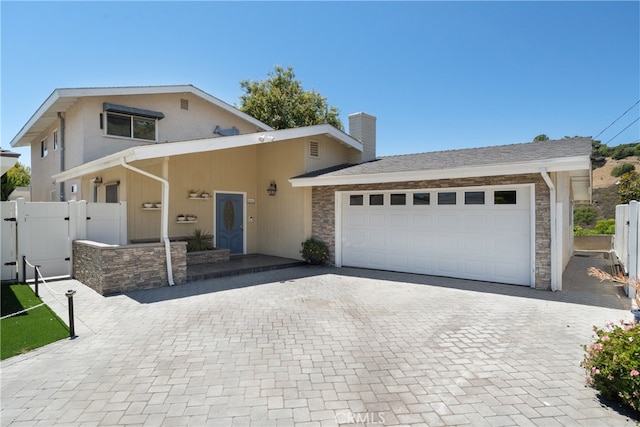 3666 Greve Dr, Rancho Palos Verdes, CA 90275 - view of front of property with decorative driveway, a chimney, a garage, a gate, and stone siding