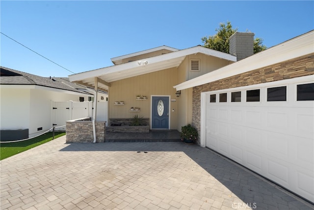 3666 Greve Dr, Rancho Palos Verdes, CA 90275 - property entrance featuring stone siding, decorative driveway, a chimney, and a garage
