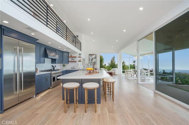 952 Via Del Monte, Palos Verdes Estates, CA 90274 - kitchen with blue cabinets, light countertops, open shelves, a kitchen breakfast bar, and light wood-type flooring