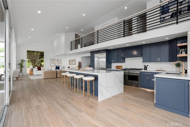 952 Via Del Monte, Palos Verdes Estates, CA 90274 - kitchen featuring blue cabinetry, open shelves, custom exhaust hood, high vaulted ceiling, and a kitchen breakfast bar