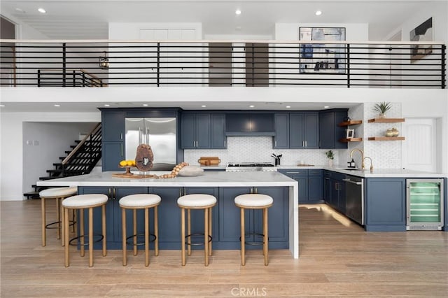 952 Via Del Monte, Palos Verdes Estates, CA 90274 - kitchen featuring wine cooler, blue cabinetry, light countertops, open shelves, and light wood-style floors