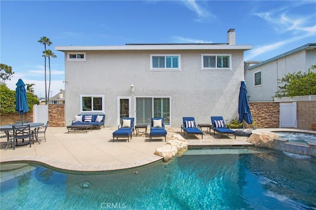 9552 Castine Dr, Huntington Beach, CA 92646 - rear view of property featuring stucco siding, a patio, a pool with connected hot tub, and a chimney