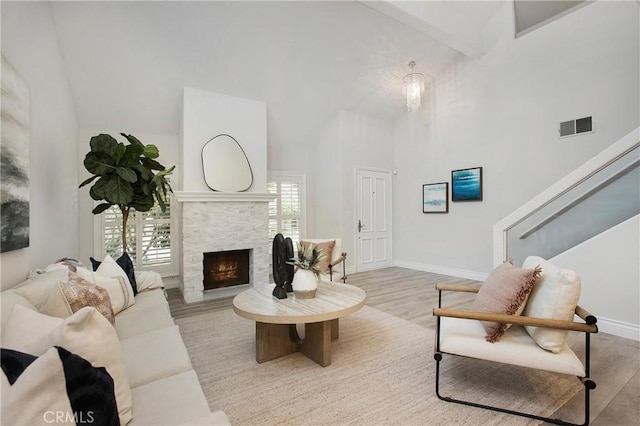 9552 Castine Dr, Huntington Beach, CA 92646 - living area with high vaulted ceiling, wood finished floors, a stone fireplace, and stairway