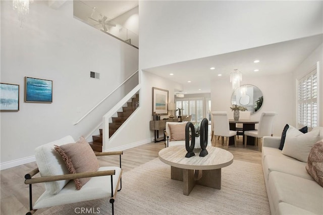 9552 Castine Dr, Huntington Beach, CA 92646 - living room with stairway, light wood-type flooring, recessed lighting, and a towering ceiling