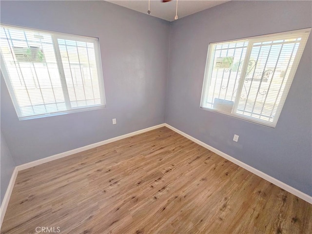 15951 M St, Mojave, CA 93501 - empty room featuring plenty of natural light, wood finished floors, and a ceiling fan