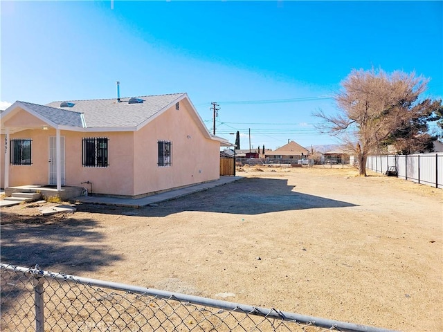 15951 M St, Mojave, CA 93501 - view of side of home with a fenced backyard, roof with shingles, and stucco siding