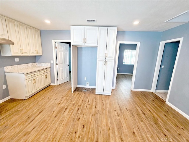 15951 M St, Mojave, CA 93501 - kitchen featuring light wood finished floors, white cabinetry, recessed lighting, and light stone countertops