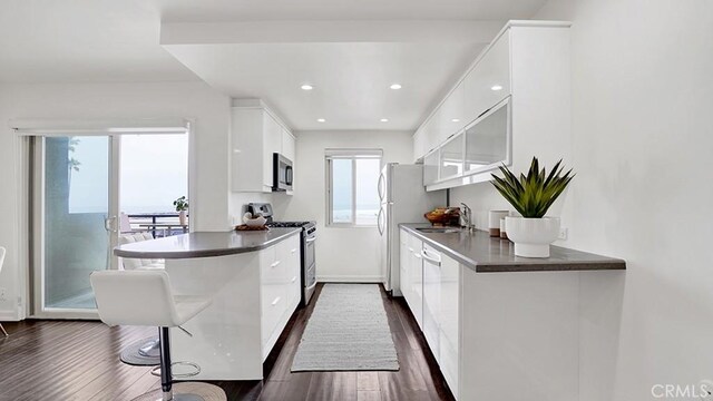 1202 N Pacific St Unit 203A, Oceanside, CA 92054 - kitchen with stainless steel range with gas stovetop, modern cabinets, white cabinetry, dark wood-type flooring, and recessed lighting