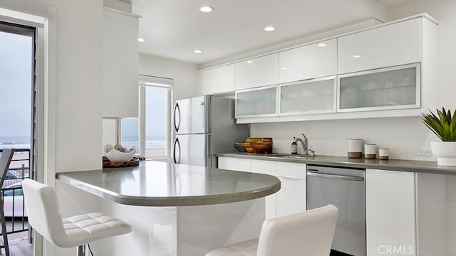 1202 N Pacific St Unit 203A, Oceanside, CA 92054 - kitchen with freestanding refrigerator, dishwasher, modern cabinets, white cabinetry, and glass insert cabinets