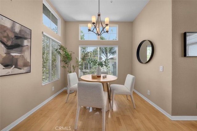 18051 Joyful Ln Unit 201, Huntington Beach, CA 92648 - dining space featuring light wood-style floors, a chandelier, and a towering ceiling