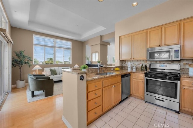 18051 Joyful Ln Unit 201, Huntington Beach, CA 92648 - kitchen with appliances with stainless steel finishes, tasteful backsplash, open floor plan, a peninsula, and recessed lighting