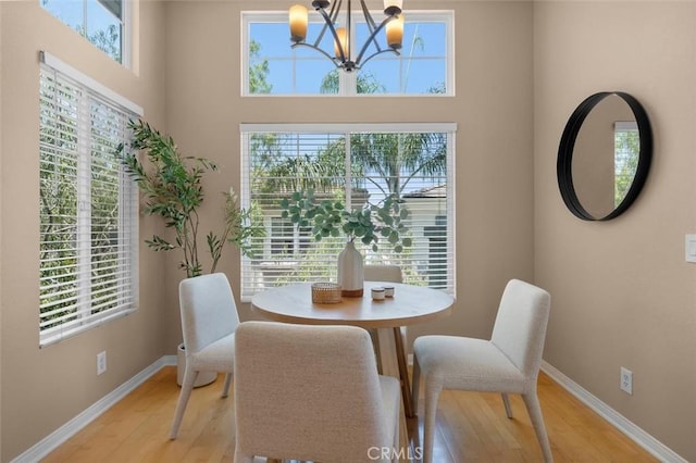 18051 Joyful Ln Unit 201, Huntington Beach, CA 92648 - dining room with light wood finished floors, a chandelier, and a towering ceiling