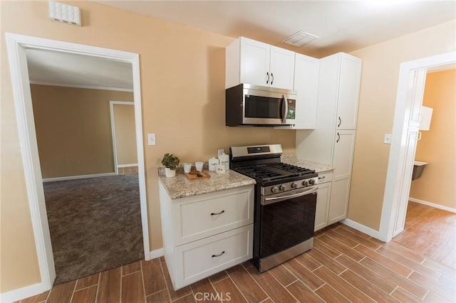 902 E Francis Ave, La Habra, CA 90631 - kitchen with stainless steel appliances, wood finish floors, white cabinets, light stone counters, and crown molding