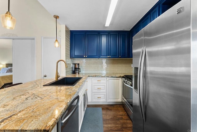 340 Isthmus Way Unit 56, Oceanside, CA 92058 - kitchen with appliances with stainless steel finishes, a peninsula, dark wood finished floors, light stone countertops, and decorative backsplash