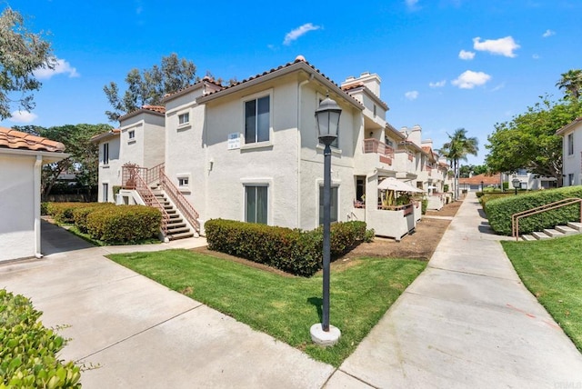 340 Isthmus Way Unit 56, Oceanside, CA 92058 - view of side of property featuring a residential view, stucco siding, and a lawn