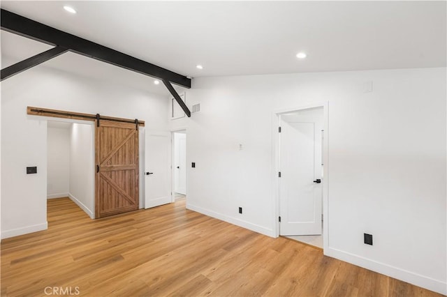 18718 Delight St, Canyon Country, CA 91351 - unfurnished bedroom with a barn door, recessed lighting, and light wood-style floors