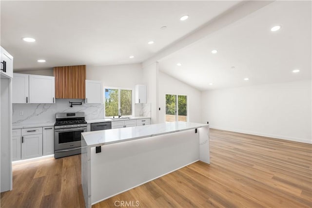 18718 Delight St, Canyon Country, CA 91351 - kitchen featuring stainless steel appliances, tasteful backsplash, white cabinets, light wood-style flooring, and light stone counters