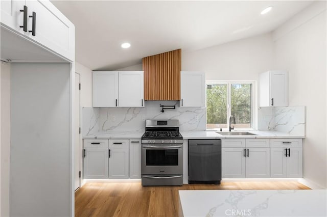 18718 Delight St, Canyon Country, CA 91351 - kitchen featuring gas stove, dishwashing machine, lofted ceiling, light wood-type flooring, and white cabinetry