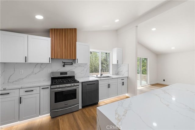 18718 Delight St, Canyon Country, CA 91351 - kitchen featuring black dishwasher, gas range, lofted ceiling, white cabinetry, and decorative backsplash