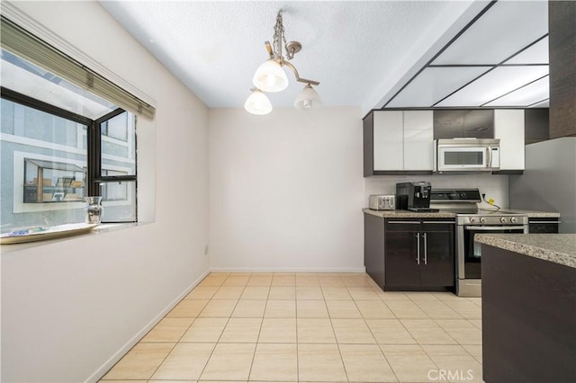 18100 Burbank Blvd Unit 11, Tarzana, CA 91356 - kitchen with appliances with stainless steel finishes, pendant lighting, light tile patterned flooring, and a textured ceiling