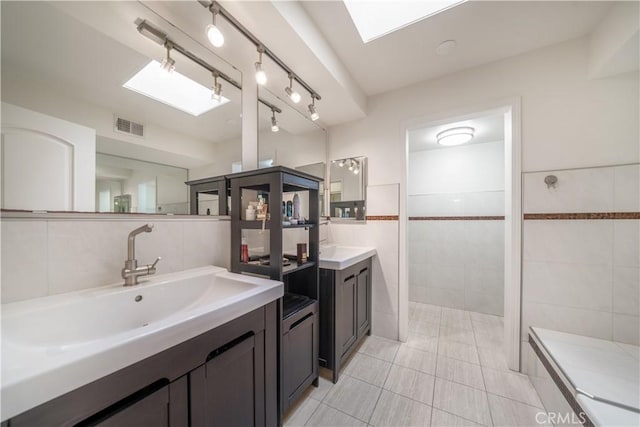 18100 Burbank Blvd Unit 11, Tarzana, CA 91356 - full bath featuring tile walls, two vanities, a skylight, tile patterned floors, and walk in shower