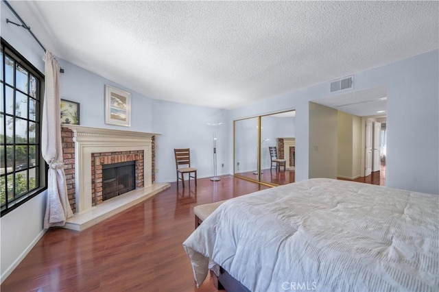 18100 Burbank Blvd Unit 11, Tarzana, CA 91356 - bedroom with a textured ceiling, wood finished floors, a closet, and a brick fireplace
