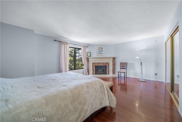 18100 Burbank Blvd Unit 11, Tarzana, CA 91356 - bedroom featuring wood finished floors, a textured ceiling, a brick fireplace, and a closet