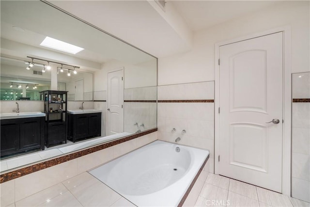 18100 Burbank Blvd Unit 11, Tarzana, CA 91356 - full bath with a garden tub, double vanity, tile patterned floors, tile walls, and a skylight