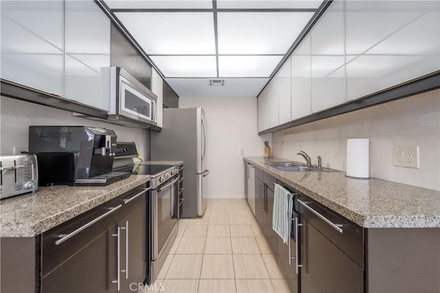 18100 Burbank Blvd Unit 11, Tarzana, CA 91356 - kitchen with appliances with stainless steel finishes, dark brown cabinets, light tile patterned floors, light countertops, and white cabinets