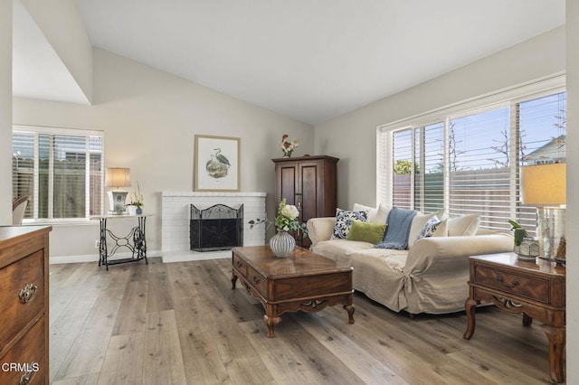 3051 Ketch Pl, Oxnard, CA 93035 - living area featuring light wood-type flooring, lofted ceiling, and a fireplace