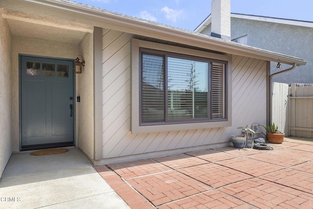 3051 Ketch Pl, Oxnard, CA 93035 - view of exterior entry with a patio, stucco siding, and a chimney
