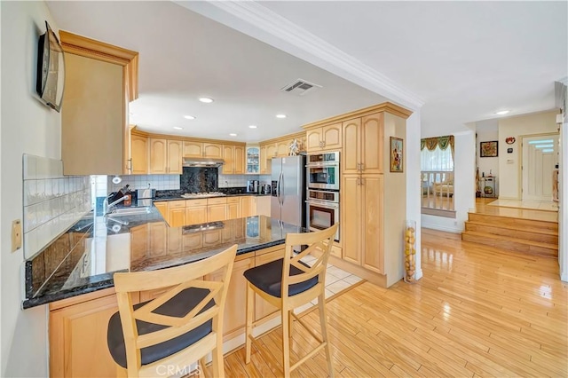 11830 Killimore Ave, Porter Ranch, CA 91326 - kitchen with appliances with stainless steel finishes, tasteful backsplash, light brown cabinets, under cabinet range hood, and glass insert cabinets