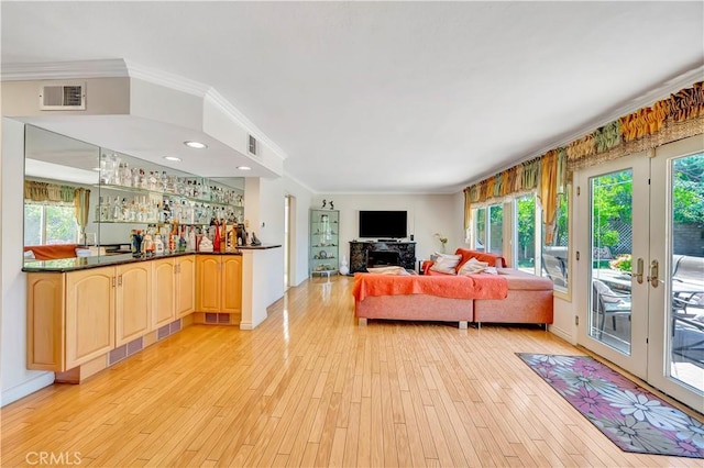 11830 Killimore Ave, Porter Ranch, CA 91326 - living room with plenty of natural light, light wood finished floors, bar, ornamental molding, and french doors