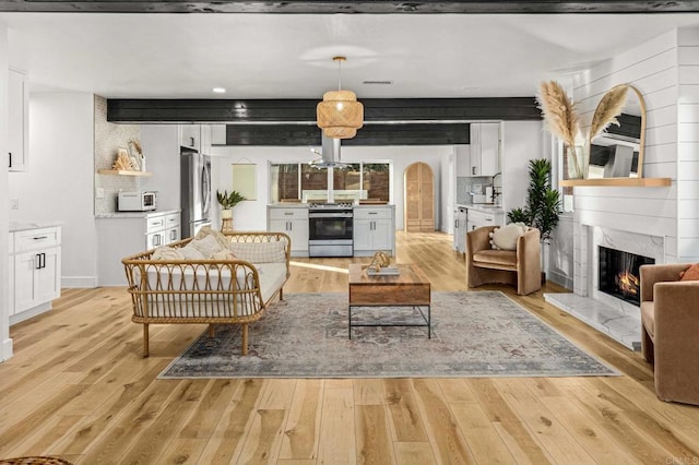 3167 Camarillo Ave, Oceanside, CA 92056 - living room featuring a premium fireplace, light wood finished floors, and arched walkways
