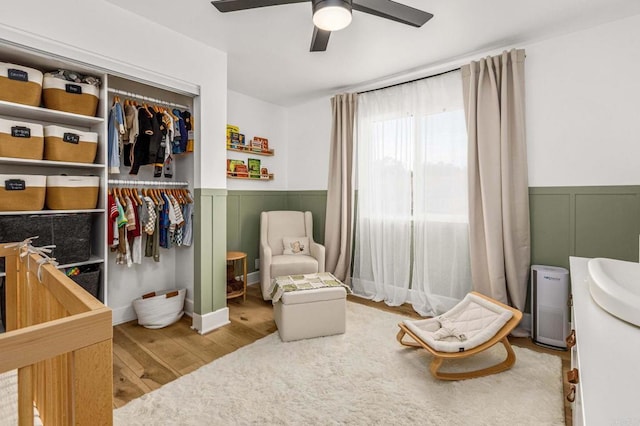3167 Camarillo Ave, Oceanside, CA 92056 - bedroom featuring a wainscoted wall, wood finished floors, ceiling fan, a decorative wall, and a closet
